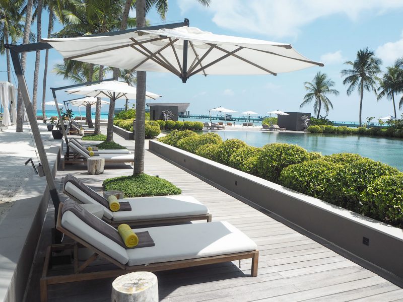 Sun lounges by the main swimming pool at Cheval Blanc Maldives